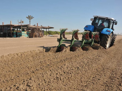 Un tractor llaura la platja del Prat el dimarts 28 de març al matí. 