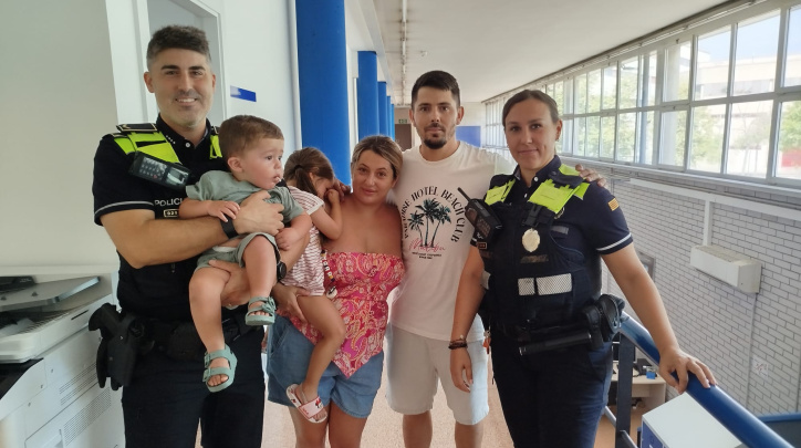L'agent i el caporal de la policia local que van salvar un infant que s'ennuegava, amb el nen, els seus pares i la seva germana.